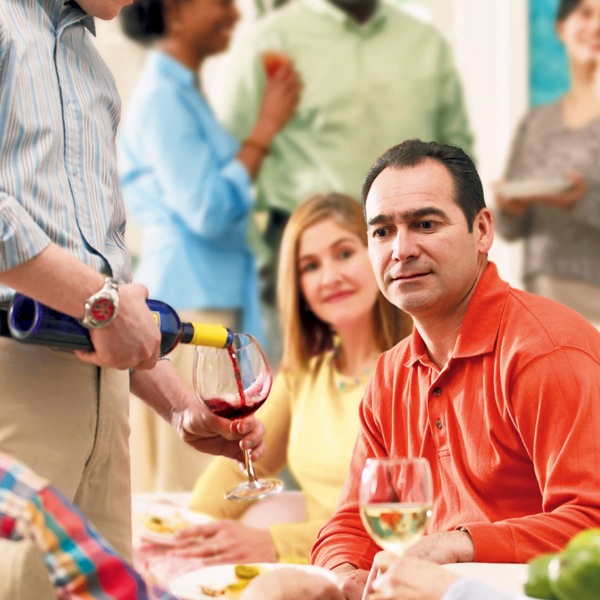 Un hombre pensando si tomar o no tomar vino en una reunión social