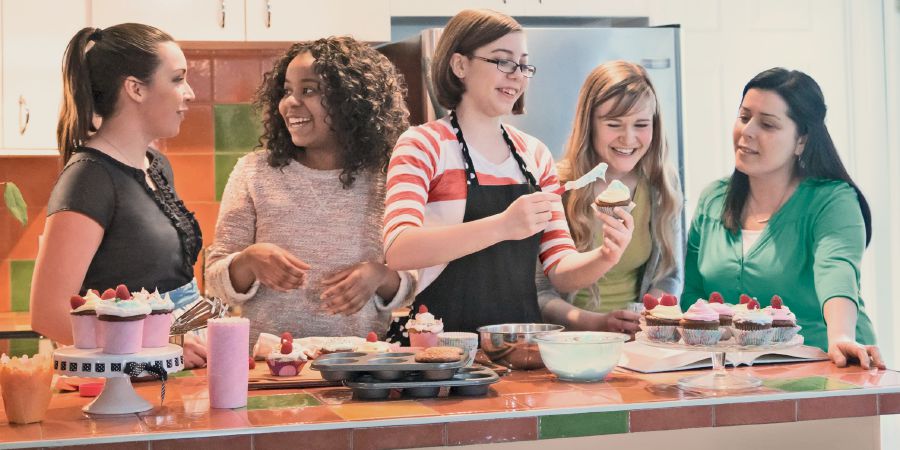 Unas adolescentes cocinando juntas un postre