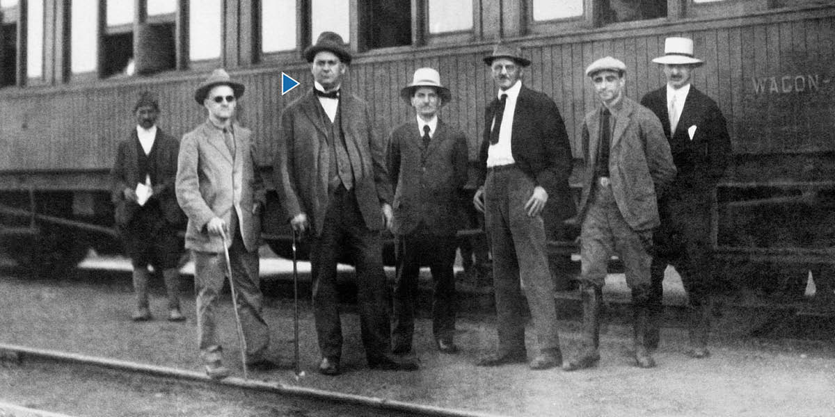 Joseph F. Rutherford en ander broers staan langs ’n trein.