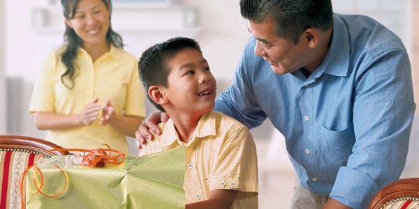 A son opening a surprise gift from his parents