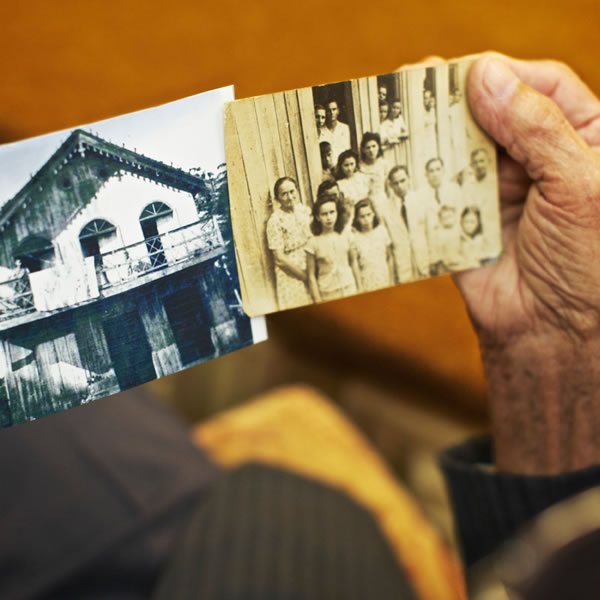 Antônio Simões mostrant dues fotografies de la primera congregació a Manapuiri, a l’estat d’Amazones (Brasil)