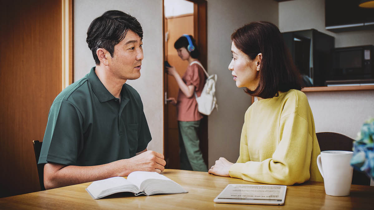 一對父母邊看聖經邊討論該怎樣向十幾歲的女兒提出勸告。