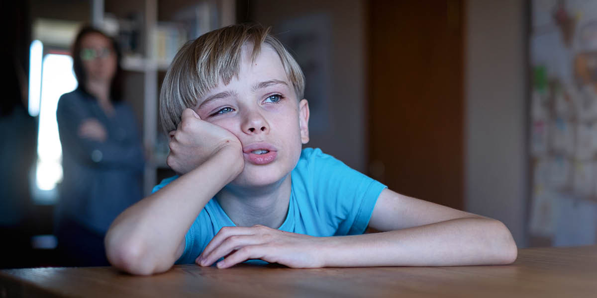 Maminka vidí, že její syn sedí znuděně u stolu a zírá z okna