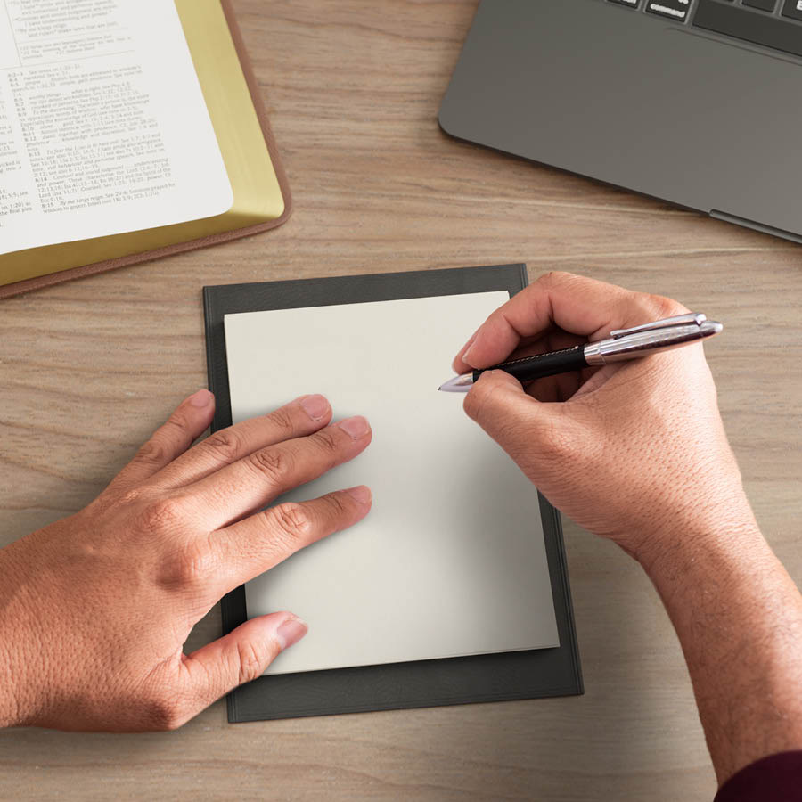 El hombre escribe en su libreta.