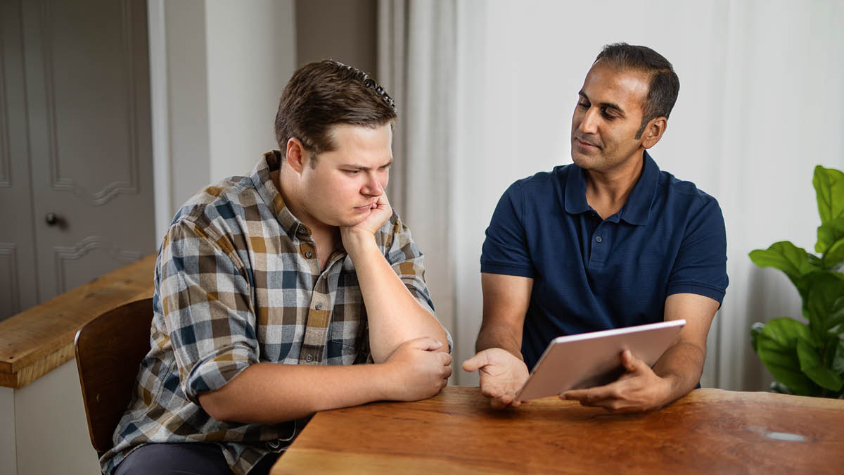 El anciano le da al hermano un consejo basado en la Biblia. Al hermano le cuesta aceptarlo.