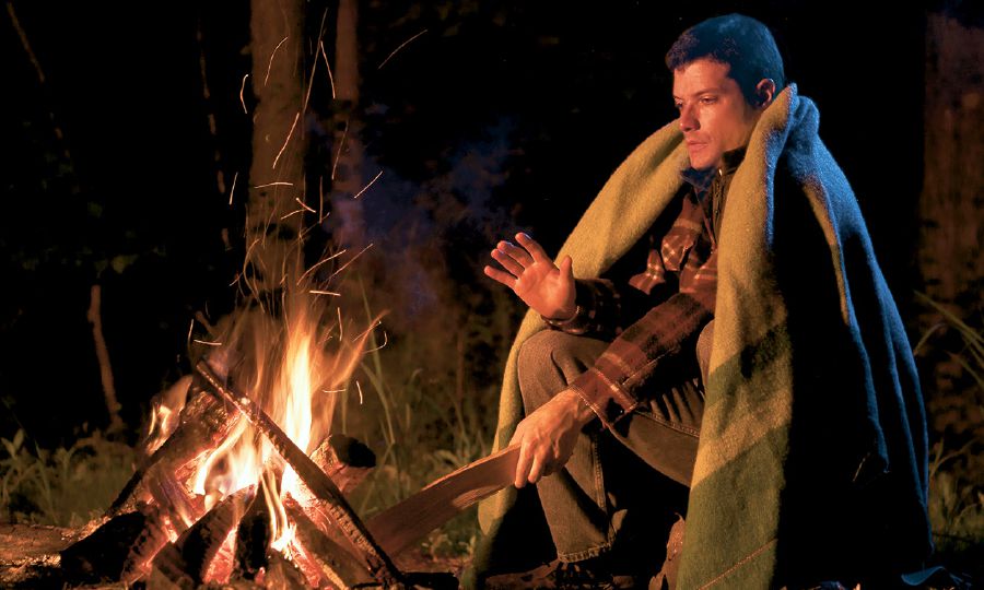 Ein Mann wärmt sich an einem Feuer