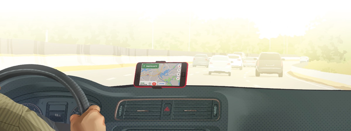 Jemand fährt mit einem Auto auf einer Straße. Ein Navigationsgerät am Armaturenbrett hilft dem Fahrer, auf dem richtigen Weg zu bleiben.