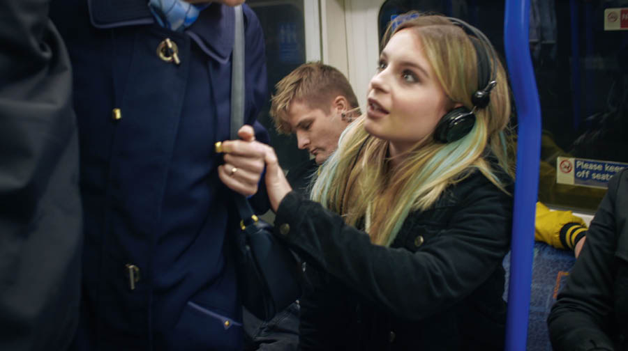 Eine Szene aus dem Video „Erlebe die Freude, Jünger zu machen – Werde ein besserer Bibellehrer: Fragen stellen“. Lotte bietet in der Bahn einer älteren Dame ihren Sitzplatz an.
