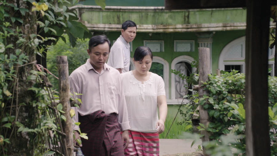 Eine Szene aus dem Video „In der Versammlung anderen Liebe zeigen – Witwen und vaterlosen Kindern“. Ein Nachbar beobachtet, wie ein Bruder und seine Frau Schwester Myint und ihre Töchter besuchen.
