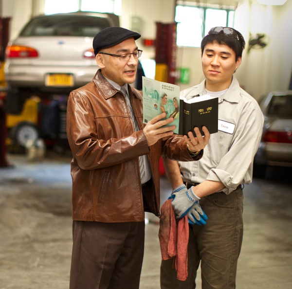 Ein Zeuge Jehovas liest einem jungen Mann aus der Bibel vor