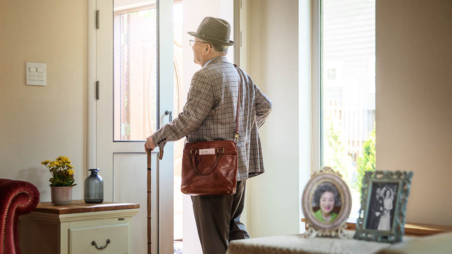 Ein verwitweter älterer Bruder verlässt seine Wohnung, um in den Predigtdienst zu gehen. Auf einem Tischchen steht ein Foto seiner Frau und ein Hochzeitsfoto.