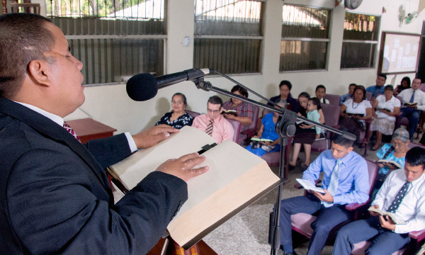 Julio Corio dando una conferencia en una congregación de los testigos de Jehová con la ayuda de una Biblia en braille