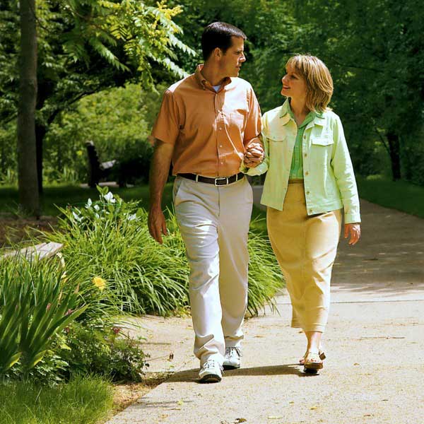 Παντρεμένο ζευγάρι περπατάει χέρι χέρι στο πάρκο