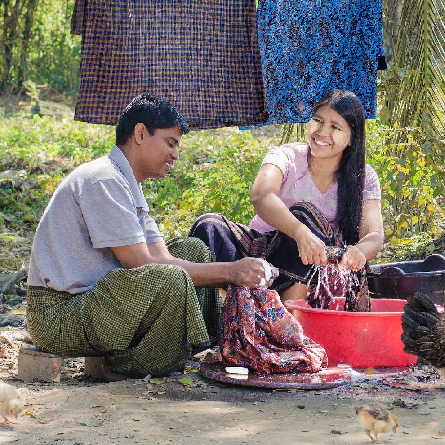 Σύζυγος βοηθάει τη γυναίκα του να πλύνει τα ρούχα σε μια λεκάνη με νερό