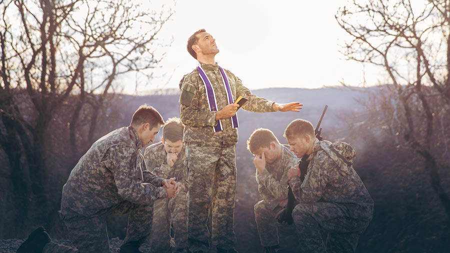 Κληρικός προσεύχεται για μια ομάδα στρατιωτών.
