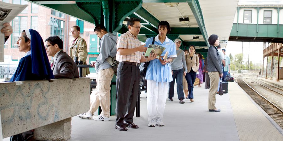 A brother witnessing to a woman at a busy train station.