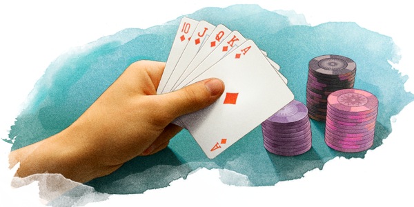 A person holds playing cards next to stacks of poker chips