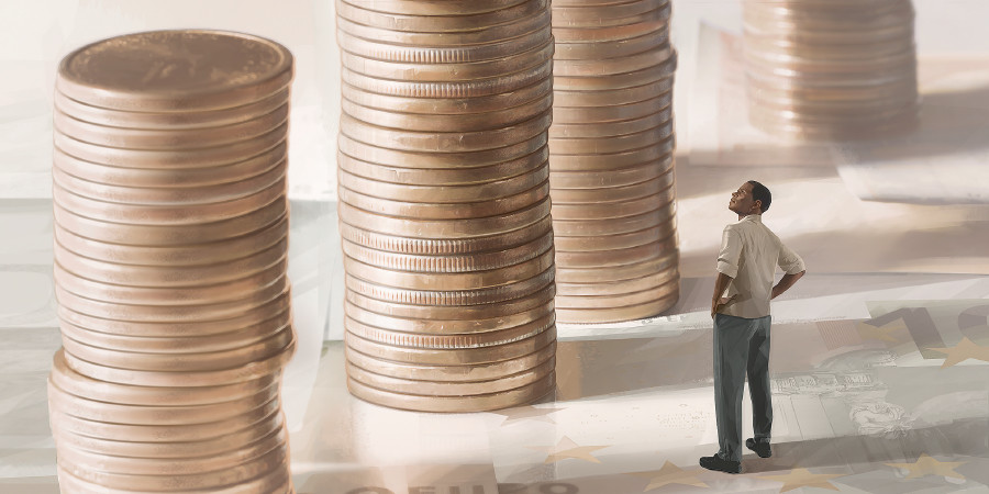 A man looks up at very tall stacks of coins