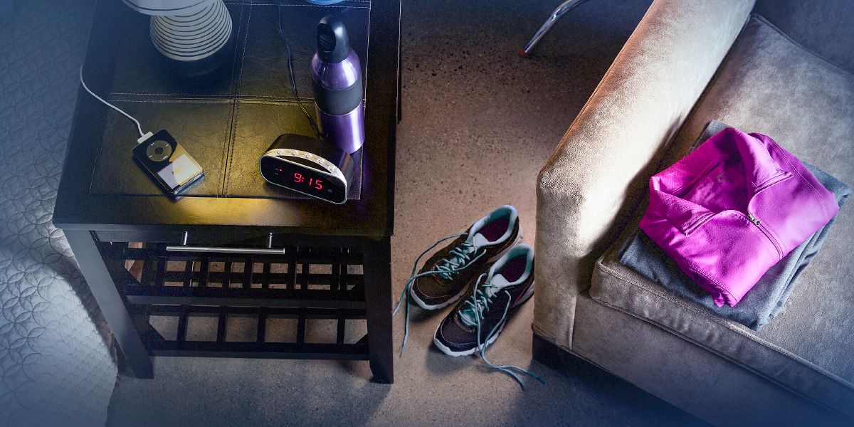 Exercise clothes, shoes, a water bottle, and a portable electronic device are set out at night