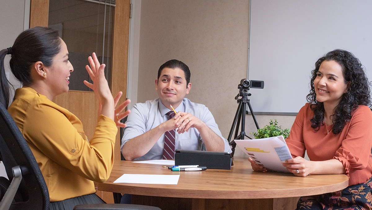 A sign-language translation team working together to translate a publication.