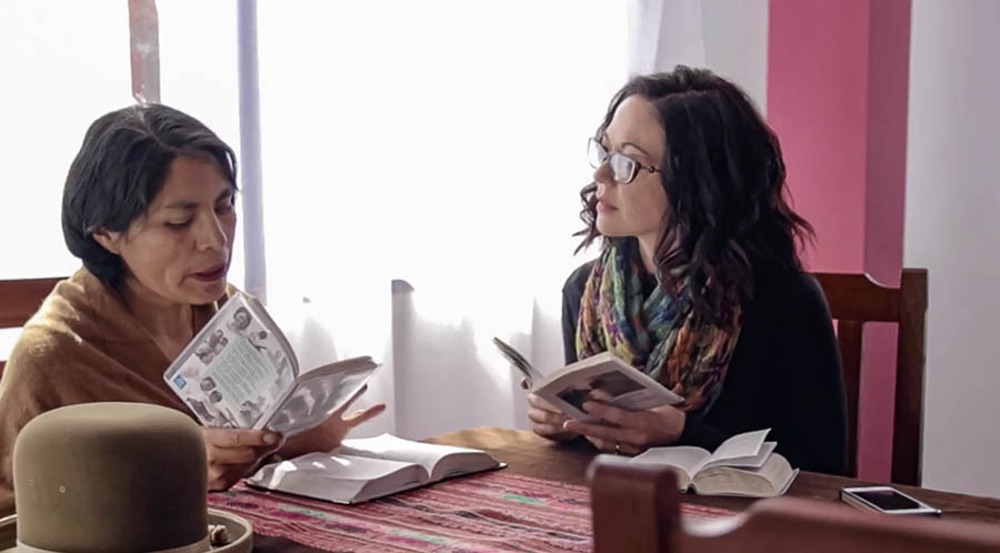 A missionary sister conducting a Bible study with a woman.