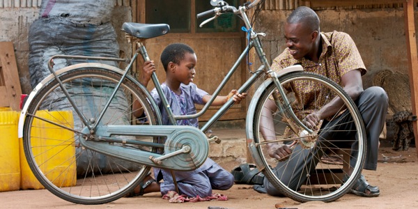 A father and son work together to repair a bicycle