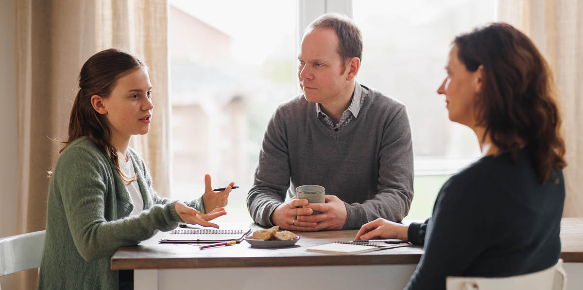 Parents listening attentively as their daughter expresses herself.