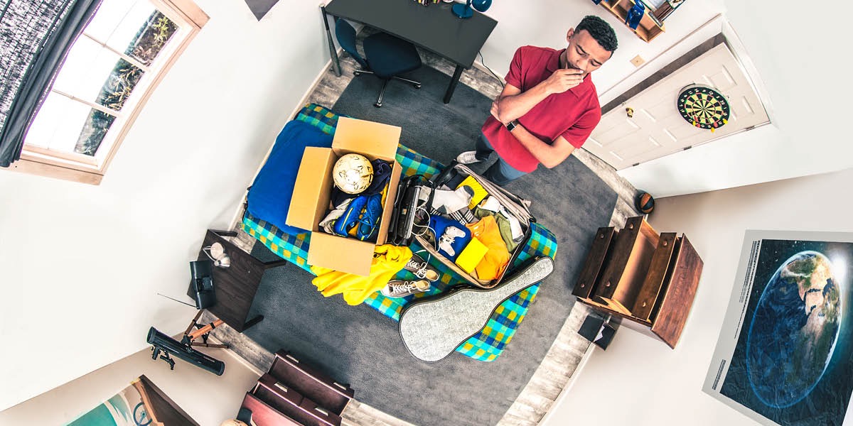 A young man packs his belongings and prepares to leave home