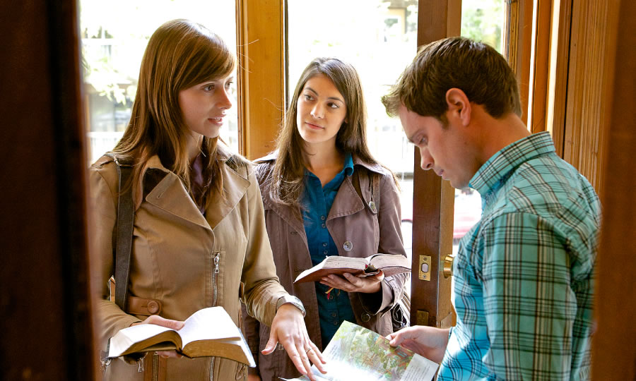 Two young Christian sisters sharing the Bible’s message with a young man