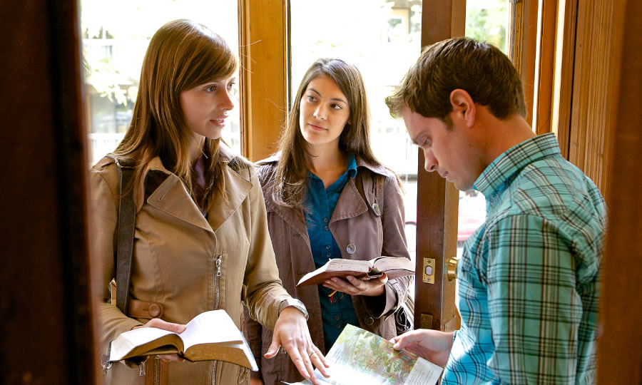 Two young Christian sisters sharing the Bible’s message with a young man