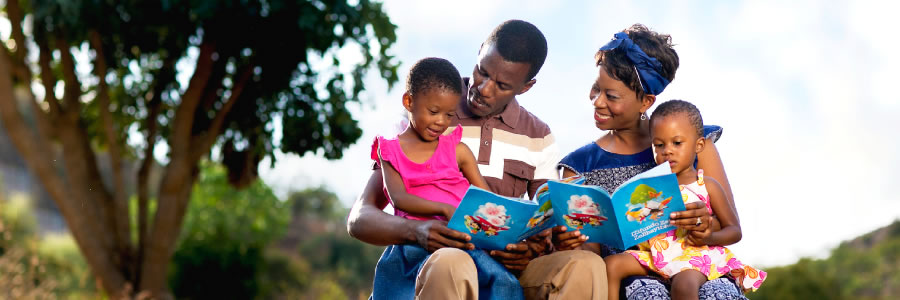 Parents and their two little girls enjoying family worship together