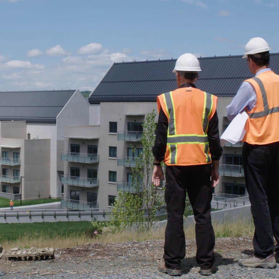 Two workers looking at newly constructed buildings at the World Headquarters of Jehovah’s Witnesses.
