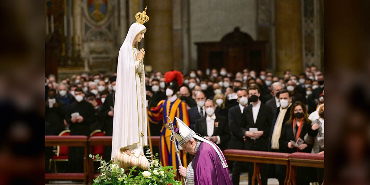 Pope Francis bowing before a statue of Mary.