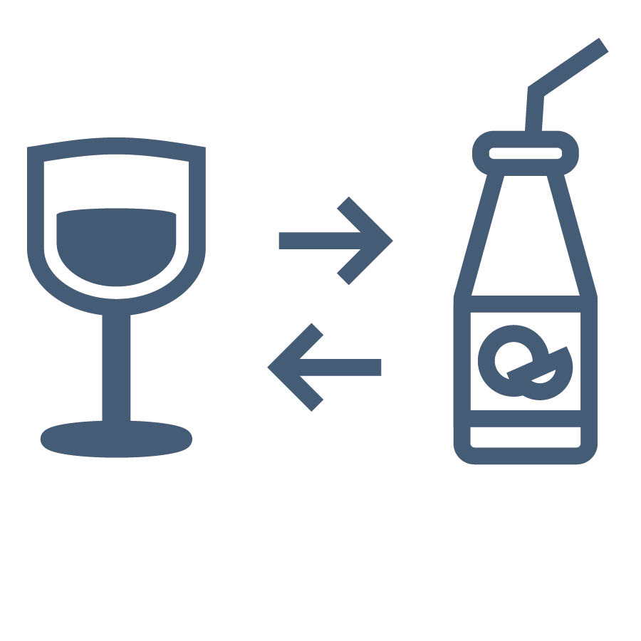 A glass of wine next to a bottle of juice.