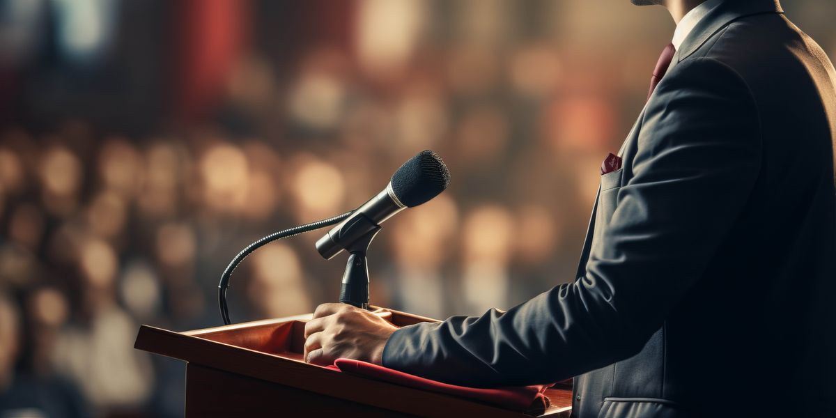 A politician addressing a crowd of people at a rally.