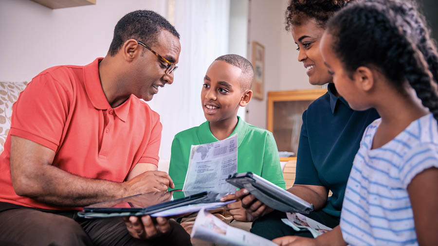 A father conducting family worship with his wife and children.