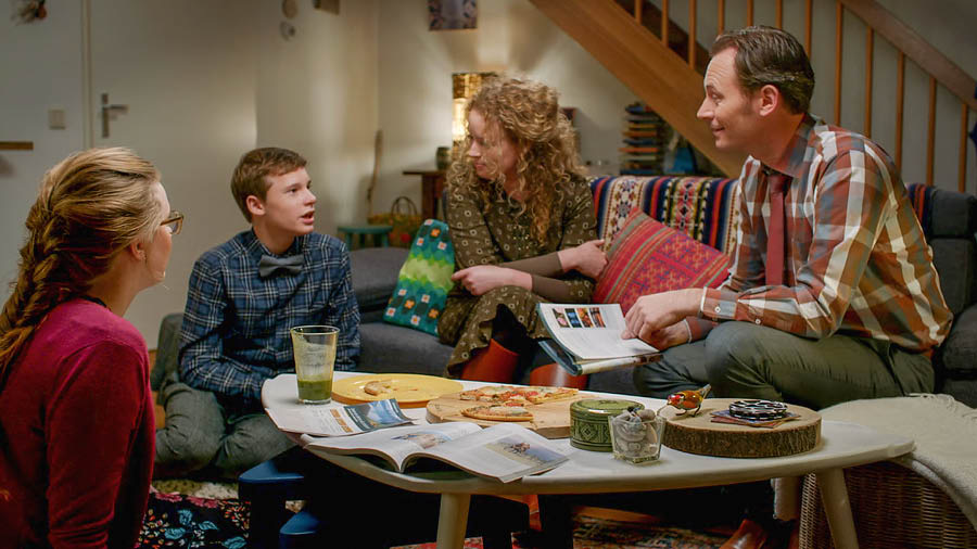 A scene from the video ‘Display Unfailing Love in Your Family.’ A family talks about points they enjoyed at their meeting as they eat a snack.