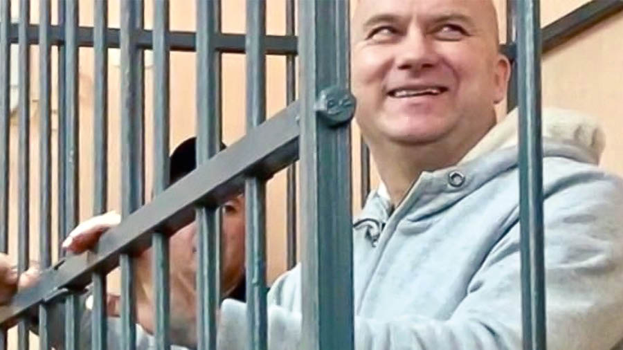 A brother smiling while in a courtroom’s holding cell.