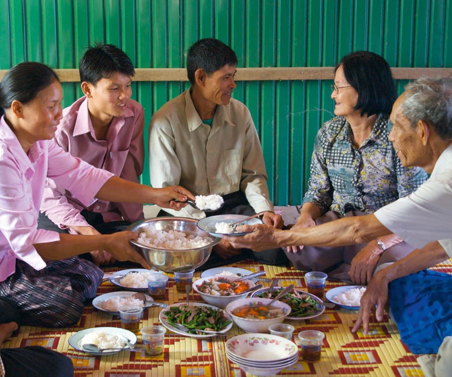 An older couple eat a meal with their adult children