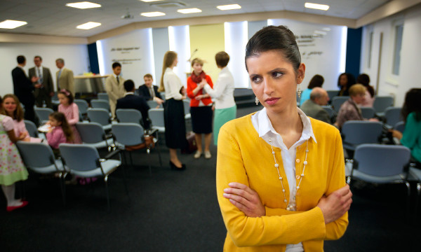 A sister at the Kingdom Hall appears hurt and resentful as she looks at another Christian sister