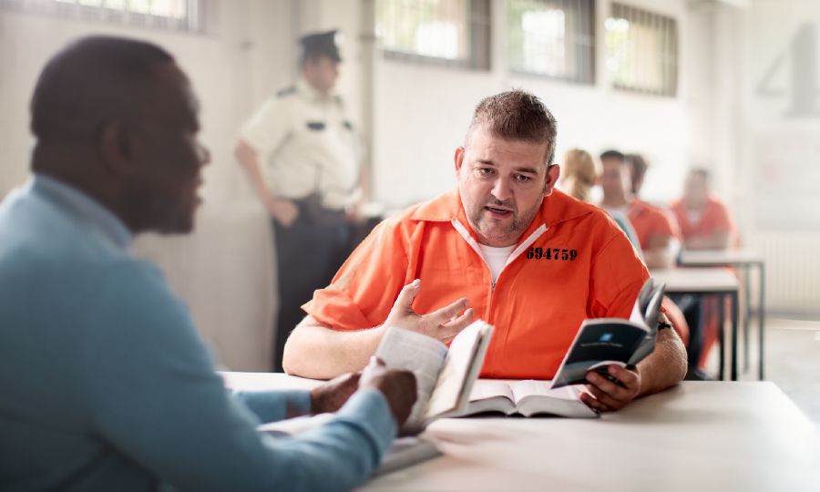 A brother conducting a Bible study with a man who is in prison.