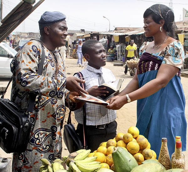 Two of Jehovah’s Witnesses preaching in an African market