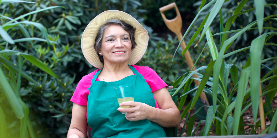 An older woman takes a break from her gardening