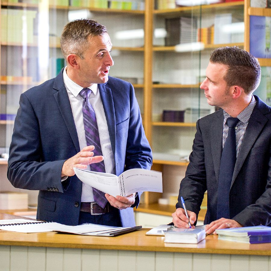 Shane talks with a local Christian brother at a literature counter in a Kingdom Hall