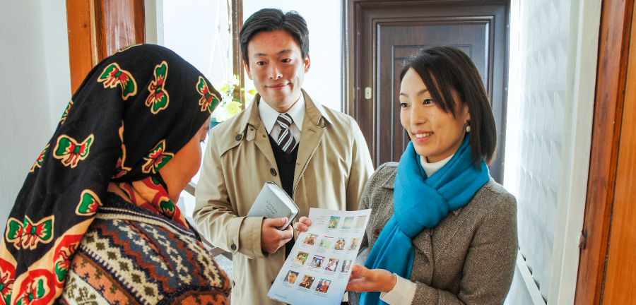 Atsuko preaches to a woman in an apartment