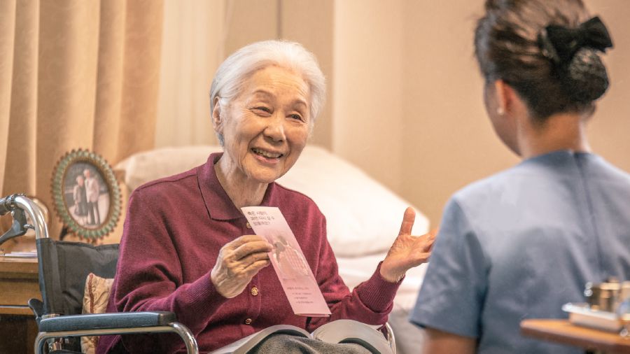 An older wheelchair-bound sister offers a tract to a health-care provider