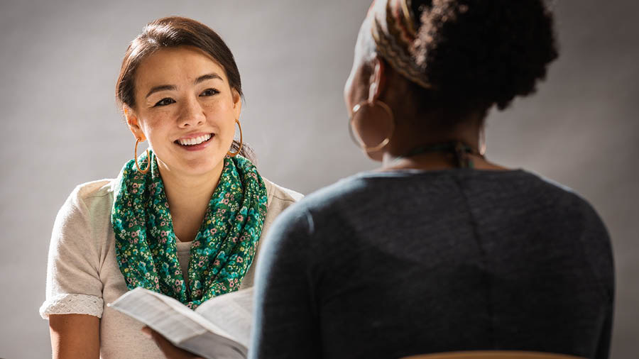 A sister happily conducting a Bible study with her student.