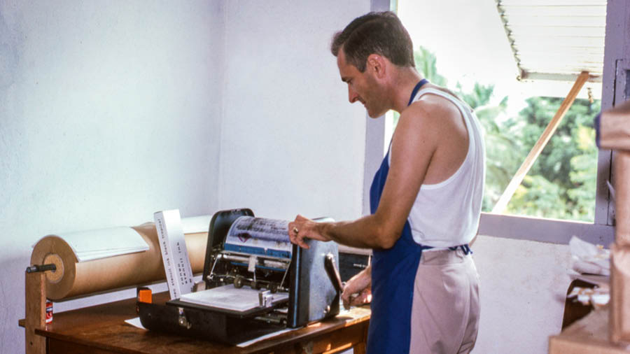 Stephen using a mimeograph machine.