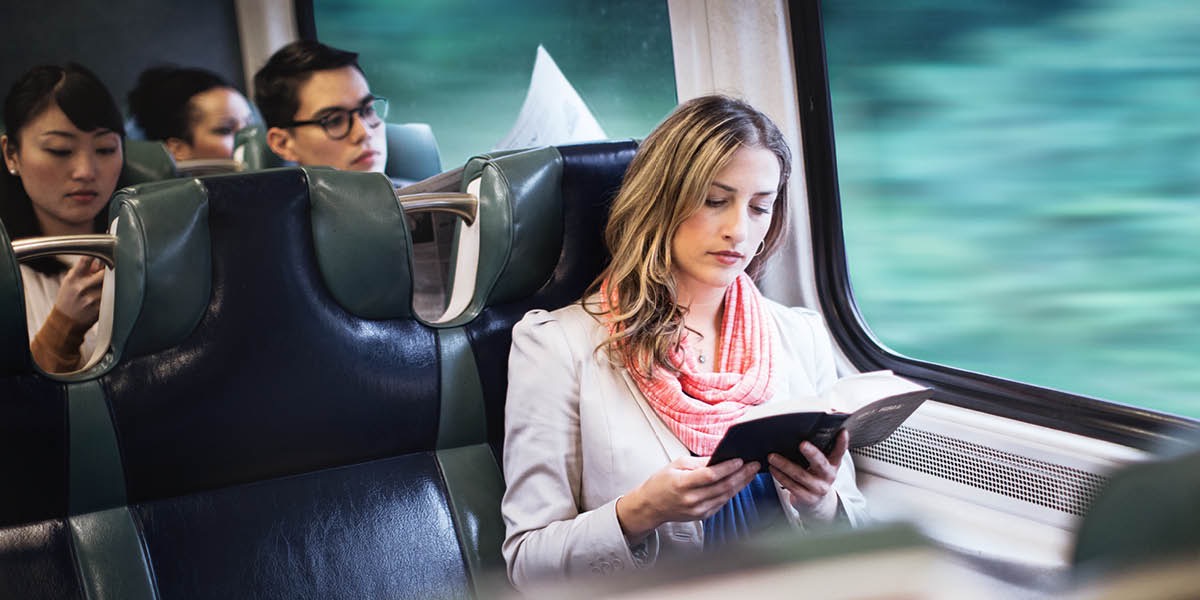 A woman reads the Bible on a train