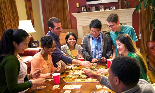 Young Christians having a good time as they play a board game